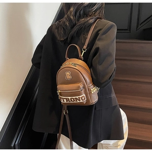 Détails de broderie d'ours et de sangle tissée sur mini sac à dos en similicuir marron