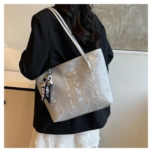 Silver tote bag with snakeskin texture and decorative polka dot scarf on shoulder strap