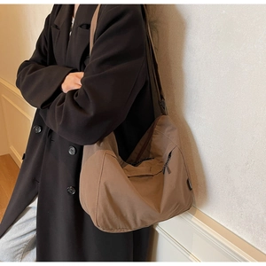 Dettaglio della borsa hobo in nylon marrone scuro con tasca laterale a zip e tracolla