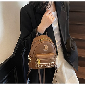 Détail du mini sac à dos en cuir PU marron foncé avec broderie ours et fermeture éclair dorée