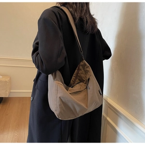 Borsa Hobo marrone capiente indossata da una modella in un ambiente interno accogliente