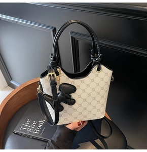 Détails d'un sac seau vintage à monogramme avec finitions dorées et breloque chien