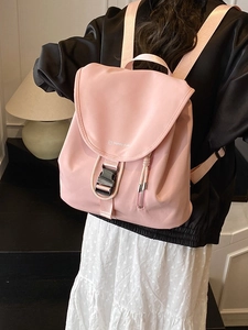 Zaino alla moda in nylon rosa impermeabile con chiusura a patta indossato da un modello