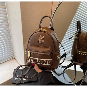 Détail du mini sac à dos marron avec broderie d'ours en peluche et rivets dorés
