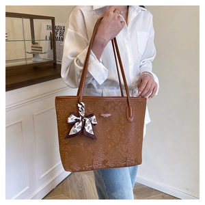 Brown snakeskin embossed tote bag with metal hardware and decorative silk scarf