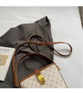 Detail of classic patterned canvas shoulder bag with smooth adjustable brown leather strap