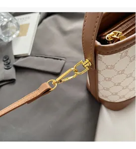 Detailed close-up of golden metal clasp and leather stitching on canvas bucket bag