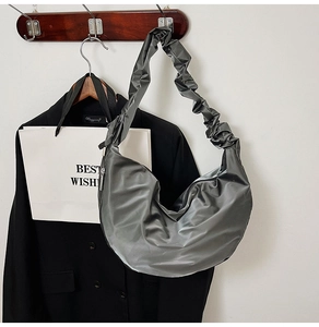 Detail of dark grey pleated shoulder bag with metallic silk texture and cloud-like strap