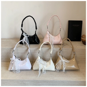 Détail de sacs demi-lune avec poignées tressées et breloques en dentelle perlée