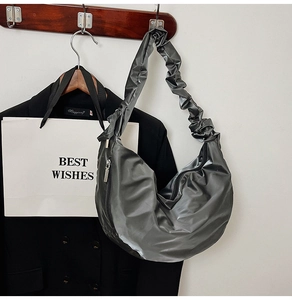Macro shot of dark grey metallic hobo bag featuring pleated straps and a half-moon shape
