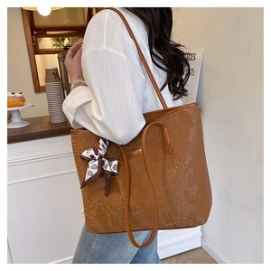 Brown faux leather tote bag with snakeskin pattern and silk scarf in a cafe setting