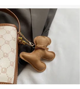 Close-up of contrast bucket bag with monogram pattern and cute leather bear charm