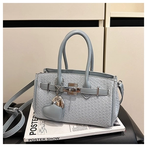 Detail of light blue woven texture Kelly bag with silver lock and heart charm