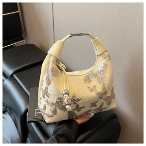 Close-up of cream leather bag featuring shimmering silver sequin butterfly embroidery