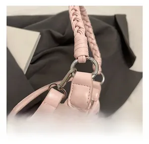 Détail du sac en cuir PU rose avec poignée tressée et attaches métalliques argentées