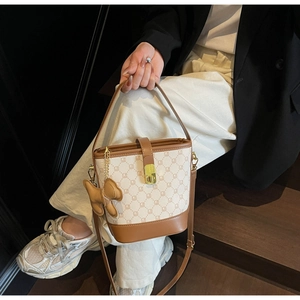 Détail d'un sac seau vintage en toile monogramme avec un accessoire de charme d'ours