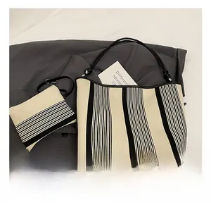 Detail view of striped canvas tote bag set with matching coin purse and leather handles