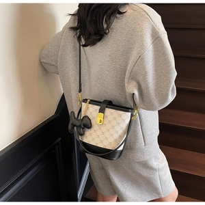 Vue détaillée du sac seau à imprimé monogramme et charm chien noir sur un modèle