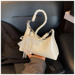 Détail du sac blanc crème avec poignée tressée et accessoire en dentelle de perles