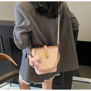 Sac seau rose à monogramme avec breloque chien et fermoir doré en vue lifestyle