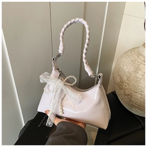 Détail du sac croissant lavande avec poignée tressée et décoration de perles élégantes