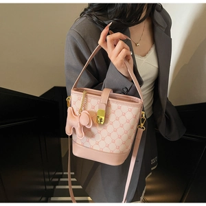 Détail du sac seau rose à damier avec fermoir métallique et breloque chien