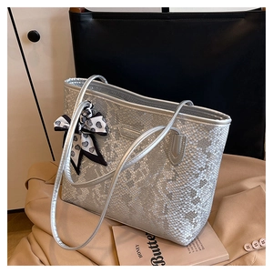 Detailed view of silver metallic snakeskin textured tote bag with a heart pattern scarf