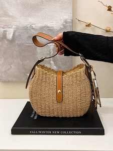 Woven straw bucket bag with brown leather shoulder strap and golden metal hardware
