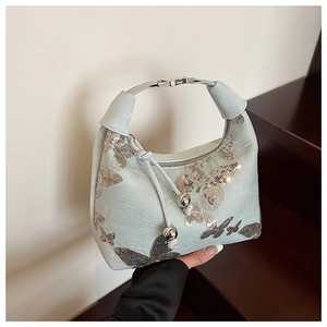 Detail of mint green hobo bag with sequined butterfly embroidery and metallic drawstring