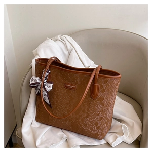 Detailed close-up of brown snake print tote bag with stylish silk scarf handle accessory