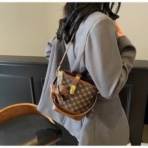 Détail du sac seau bicolore avec imprimé lettres et breloque ours mignonne