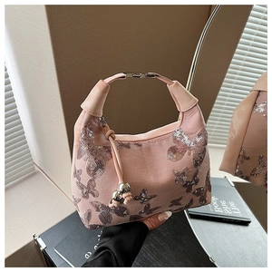Detail of pink sequin butterfly embroidery on stylish handbag with metallic clasp
