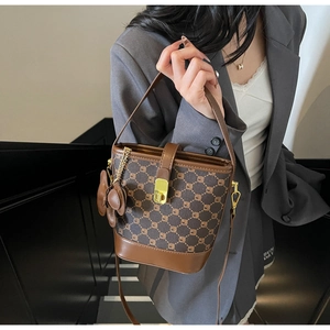 Détail du sac seau rétro avec toile monogramme marron et fermoir rotatif doré