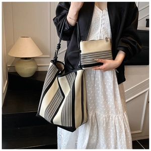 Detail of minimalist cream tote bag set with black stripes and matching inner pouch