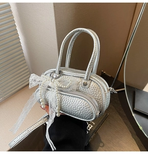 Detailed macro view of silver litchi grain handbag with pearl lace bow decoration
