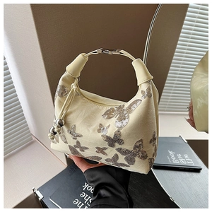Detail of silver sequin butterfly embroidery on cream PU leather handbag with metal handle