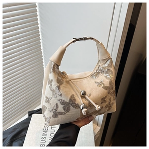 Detail of white sequined butterfly pattern and silver bead drawstring on handbag