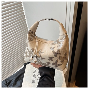 Detail of silver sequins butterfly pattern on off-white handbag with metal handle