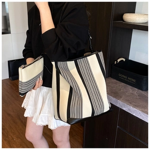 Detail of black and white striped canvas tote bag set with matching inner clutch