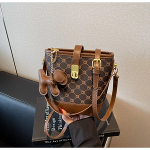 Détail du sac seau vintage avec coutures contrastées et charm de chiot mignon