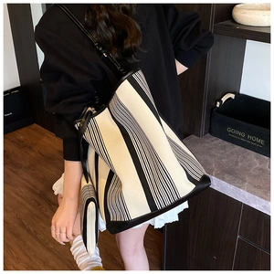 Detail of large black and white striped canvas tote bag with matching zippered clutch set