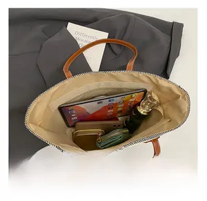 Macro view showing the large internal capacity of the straw tote bag with zipper pocket