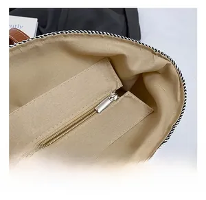 Close-up of internal lining with silver zipper pocket on woven shoulder bag
