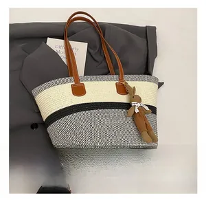 Detail show of woven straw bucket bag with striped pattern and rabbit charm