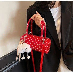 Close-up of red polka dot cylinder handbag with a cute white cloud plush pendant