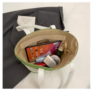 Vista superior del bolso tote de paja que muestra el interior espacioso y bolsillo con cremallera
