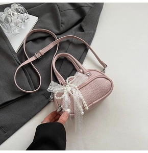 Detail of pink lychee texture bag with white lace bow and pearl decoration
