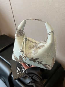 Mint green shoulder bag featuring silver sequin butterfly patterns and metallic ball pendants