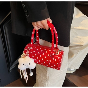 Close-up of red and white polka dot cylinder bag with a cute cloud charm detail