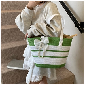 Detalle de bolsa de playa a rayas verdes y blancas con lazo de organza y perlas